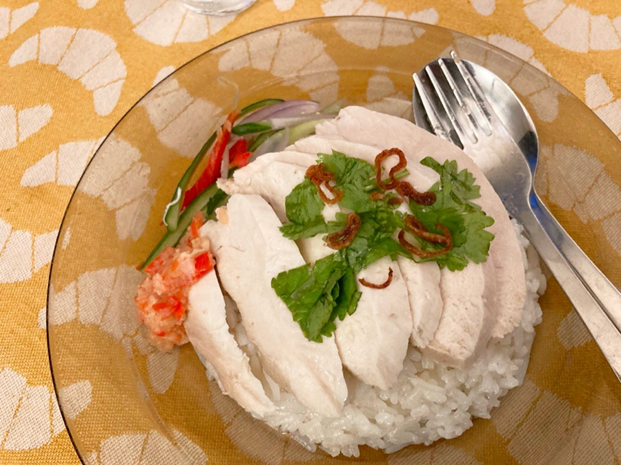 Sliced poached chicken over rice, with chilli and coriander.