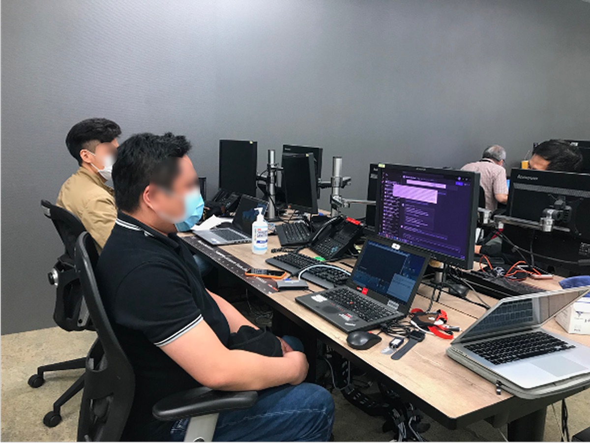 Engineers working at their desks, each with several screens, during a contextual inquiry.